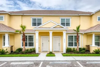 a house with palm trees in front of it at Cozy Villa Private Pool Prime Spot in Orlando