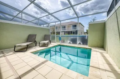 a large swimming pool with a glass ceiling and a patio at Spacious Comfortable Perfect Vacation in Orlando