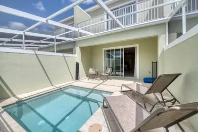 a swimming pool with two chairs and a patio at Spacious Comfortable Perfect Vacation in Orlando