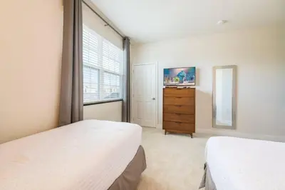 a bedroom with two beds and a dresser and a window at Spacious Comfortable Perfect Vacation in Orlando