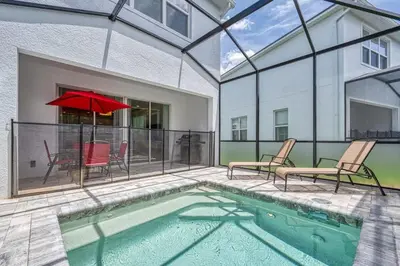 a swimming pool with chairs and a red umbrella at Modern Luxury Retreat - Mickey & Harry Potter Beds in Orlando