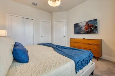 a bedroom with a bed and a dresser with a painting on the wall at Modern Luxury Retreat - Mickey & Harry Potter Beds in Orlando
