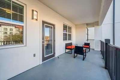 a balcony with chairs and a table and a window at Prime Location-Spacious Condo for 8 Guests in Orlando