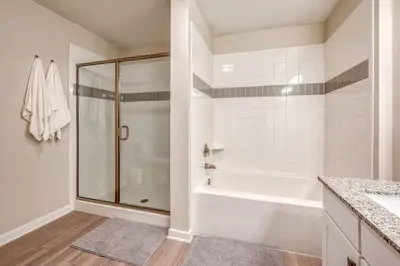 a bathroom with a shower and a white tub at Prime Location-Spacious Condo for 8 Guests in Orlando