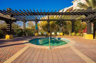 a swimming pool in a courtyard with a pergola at Prime Location-Spacious Condo for 8 Guests in Orlando