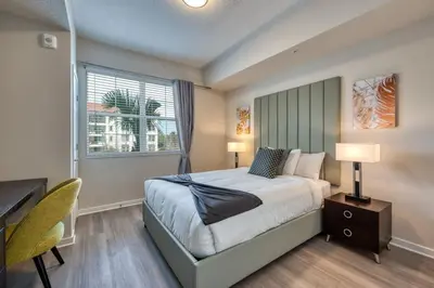 a bedroom with a bed and a desk and a window at Prime Location-Spacious Condo for 8 Guests in Orlando
