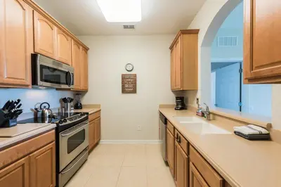 a kitchen with wooden cabinets and a stove top oven at Central Elegance-Spacious Beautifully Decor Condo in Orlando