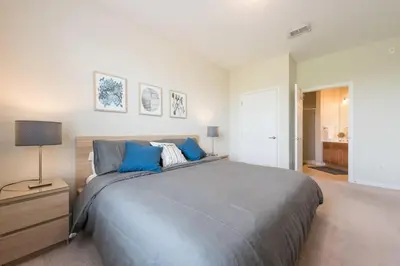 a bedroom with a large bed with blue pillows at Central Elegance-Spacious Beautifully Decor Condo in Orlando