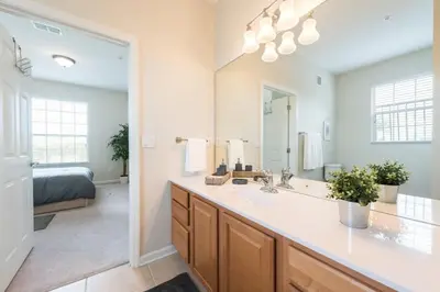 a bathroom with a sink and a large mirror at Central Elegance-Spacious Beautifully Decor Condo in Orlando