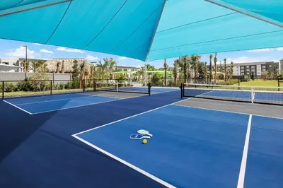 a tennis court with a racket and a ball on it at Villatel Orlando Resort in Orlando