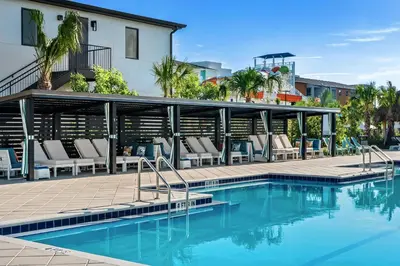 a swimming pool with lounge chairs next to a building at Villatel Orlando Resort in Orlando