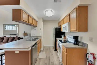 a kitchen with wooden cabinets and a counter top at Gorgeous Place Minutes Away from Attractions in Kissimmee