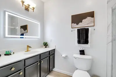 a white bathroom with a sink and a toilet at The Secret Rose Apartment - Modern & Stylish - 8 Mins from Disney in Kissimmee