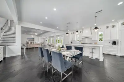 a white kitchen with a long table and blue chairs at Celebration FL 34747 in Orlando