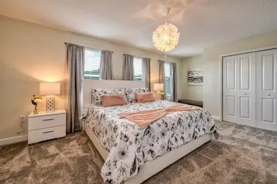 a bedroom with a large bed and a chandelier at Chic Luxury Decor Prime Location Game Room Bliss in Kissimmee