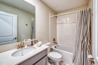 a bathroom with a sink and a toilet and a tub at Chic Luxury Decor Prime Location Game Room Bliss in Kissimmee