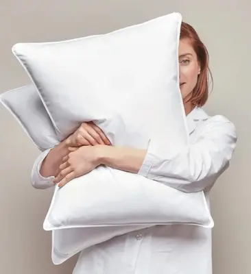 a woman in a white shirt hugging a pillow at DisneyResortVillas by AmericanVacationLiving 1 BR in Orlando
