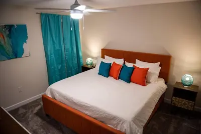 a bedroom with a bed with orange and blue pillows at Luxury and Fun near DISNEY PARKS 9BR in Kissimmee