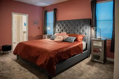 a bedroom with a large bed with red walls at Luxury and Fun near DISNEY PARKS 9BR in Kissimmee