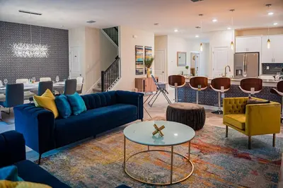 a living room with a blue couch and a table at Luxury and Fun near DISNEY PARKS 9BR in Kissimmee
