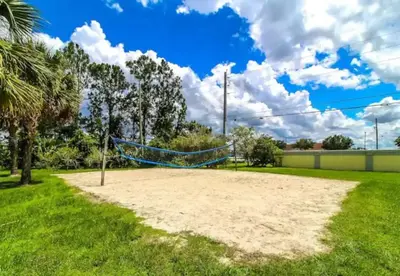 a sand volleyball court in a park with palm trees at DONOT BOOK thakn you in Kissimmee