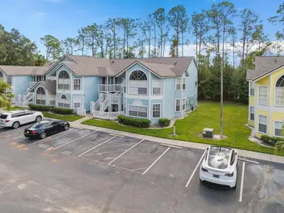 a large blue house with a car parked in a parking lot at DONOT BOOK thakn you in Kissimmee