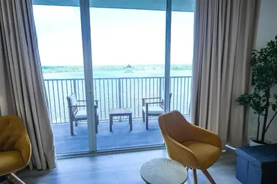 a living room with a balcony with a view of the water at Orlando Blue Heron Beach Resort Renewed apartment in Orlando