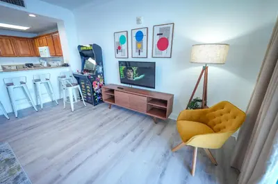 a living room with a yellow chair and a table at Orlando Blue Heron Beach Resort Renewed apartment in Orlando