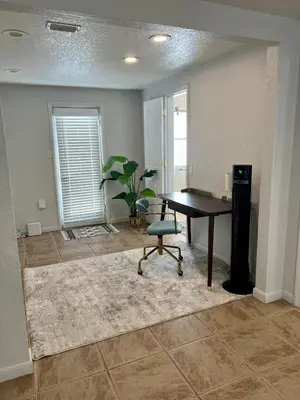 a living room with a table and a chair at Beautiful Bungalow in Orlando
