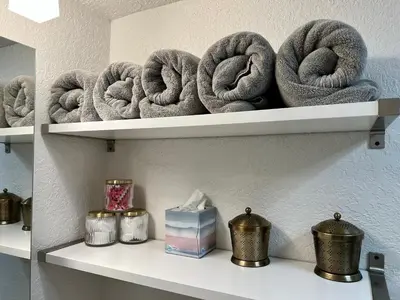 a shelf with a bunch of rolled up towels at Beautiful Bungalow in Orlando