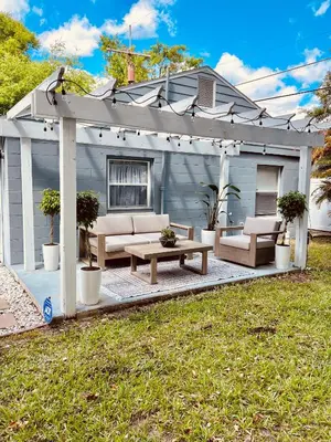 a pergola with a bench and a table on a patio at Beautiful Bungalow in Orlando