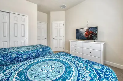 a bedroom with two beds and a tv on a dresser at Distinctive Home Private Pool in Orlando