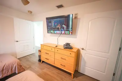 a bedroom with a dresser and a tv on the wall at ORLANDO - BLUE HERON Great Apt - 7 pax in Orlando