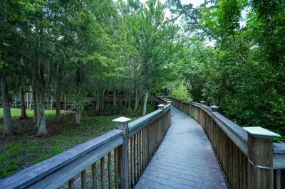 a wooden bridge with a wooden fence and trees at ORLANDO - BLUE HERON Great Apt - 7 pax in Orlando