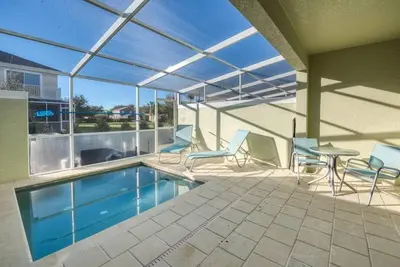 a patio with a pool and chairs and a table at Super cozy home with private pool in Orlando