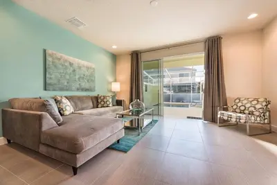 a living room with a couch and a table at Super cozy home with private pool in Orlando
