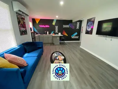 a living room with a blue couch and a table at Totally 80s! in Sanford