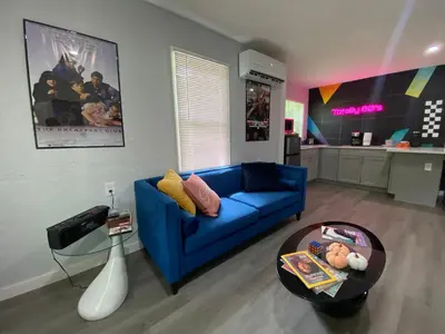 a living room with a blue couch and a table at Totally 80s! in Sanford