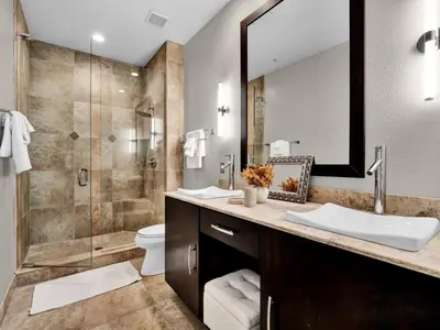a bathroom with a shower and two sinks and a mirror at Beautiful townhouse centrally located in Orlando