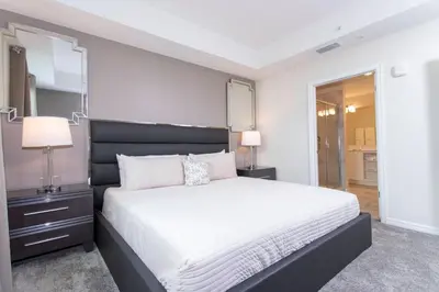 a bedroom with a large bed and a mirror at Poolside Paradise at Storey Lake: 2-Bedroom in Kissimmee