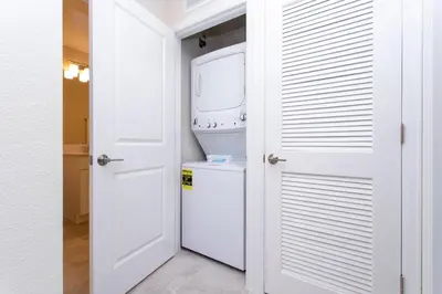 a white laundry room with a washer and dryer at Poolside Paradise at Storey Lake: 2-Bedroom in Kissimmee