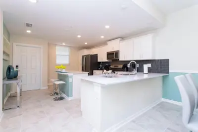a kitchen with white cabinets and a counter top at Poolside Paradise at Storey Lake: 2-Bedroom in Kissimmee