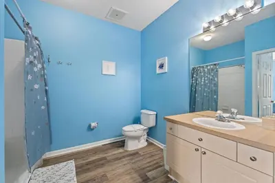 a blue bathroom with a toilet and a sink at Mickey's Whimsical Wonderland in Kissimmee