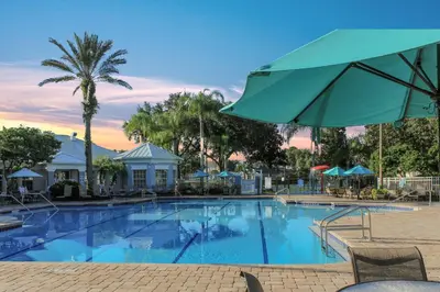 a large swimming pool with a green umbrella at Mickey's Whimsical Wonderland in Kissimmee