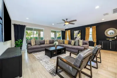 a living room with a couch and a table at EPIC 10min Disney Fun Villa, Mini Golf, Arcade, Theater in Orlando