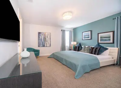 a bedroom with a bed and a flat screen tv at EPIC Disney 10Min Retreat, 8BR Resort Villa and Arcade in Orlando