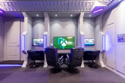 a video game room with two chairs and a television at EPIC Disney 10Min Retreat, 8BR Resort Villa and Arcade in Orlando