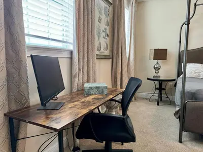 a desk with a computer and a chair in a bedroom at 411-IBRHAIM · 411 Sparkling Spotless Villa in Encore in Orlando