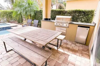 a patio with a table and a stove and a grill at 411-IBRHAIM · 411 Sparkling Spotless Villa in Encore in Orlando