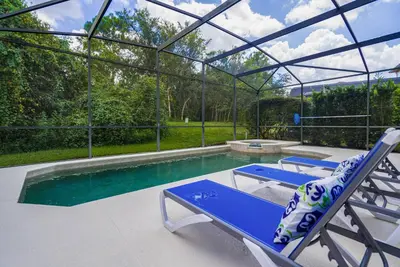 a pool with two blue chairs and a swimming pool at Great 6bedrooms home in Kissimmee w Private Pool 8426 in Kissimmee
